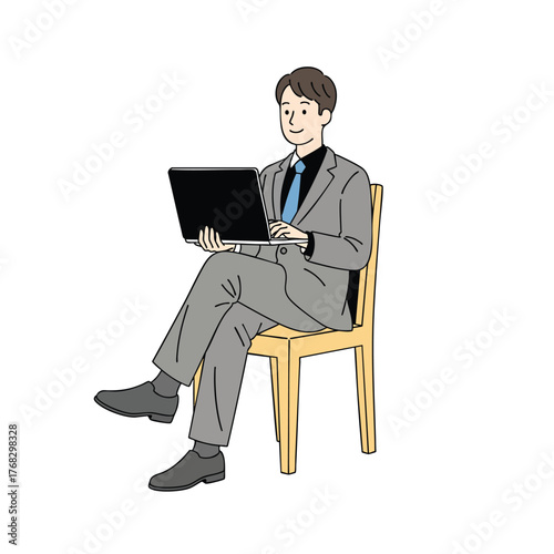 A smiling businessman in a grey suit sitting crosslegged on a chair while working on his laptop.