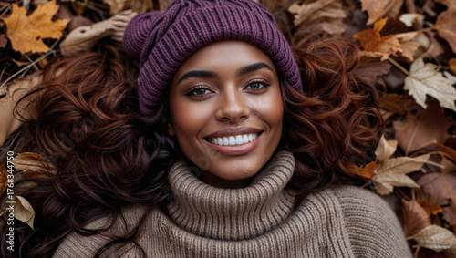 Black girl mixed ethnical wearing wool knitted hat in autumn scenery with colourful leaves