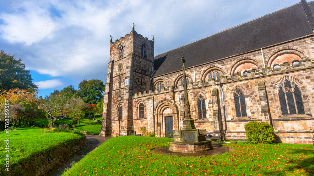 Fototapeta premium Historic stone church with tower and ancient cross
