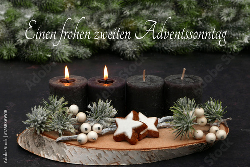  Arrangement für den zweiten Advent : Dekoration mit vier braunen Adventskerzen, Tannenzweigen und Zimtsternen auf einer Holzscheibe dekoriert.