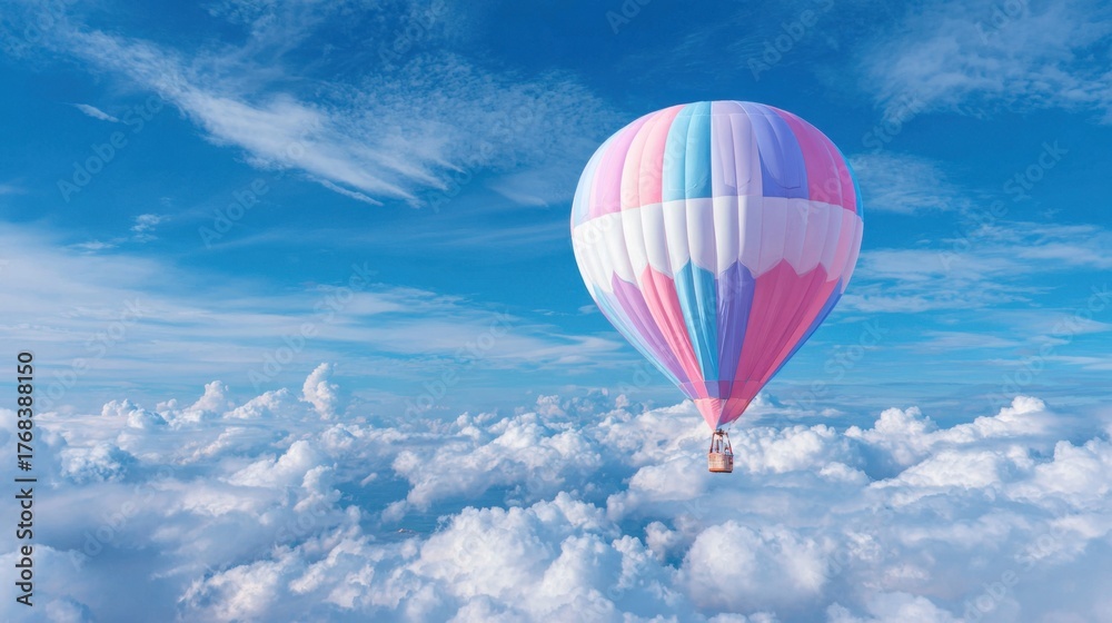 Fototapeta premium A vibrant hot air balloon drifts gracefully among soft clouds under a clear blue sky.