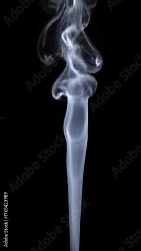 Wispy column of smoke ascends against a stark black backdrop, creating a surreal shape