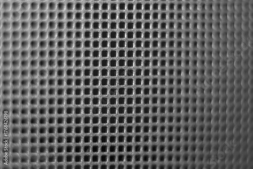 Monochrome macro image of perforation, emphasizing the play of light and shadow