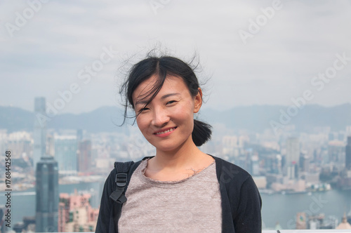 a chinese woman with hong kong city view background