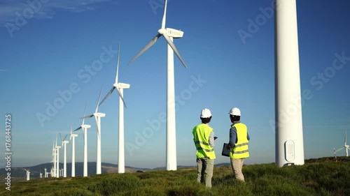 Engineers discussing wind energy project at wind farm, Spain