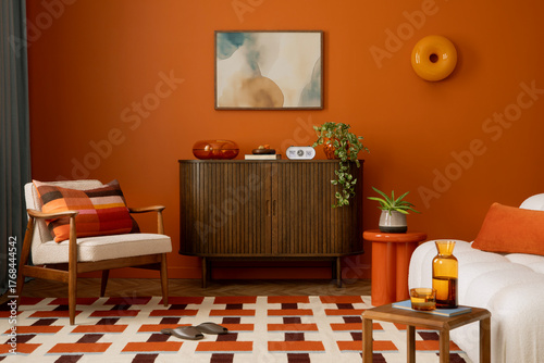 Mid-century inspired living room with orange walls, soft fabrics, and modern art on the wall.