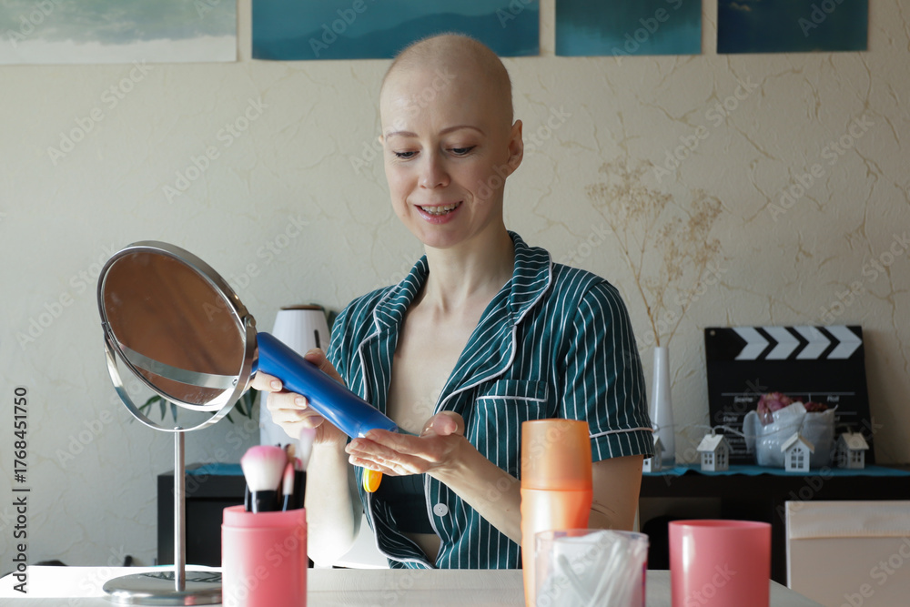 Φωτογραφία Smiling bald woman in striped pajamas compares two SPF skincare bottles, choosin