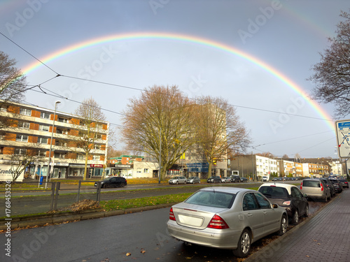 Ein kompletter Regenbogen zieht sich über eine Straße