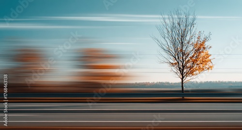 Motion blur captures a lone tree against a streaking autumn landscape