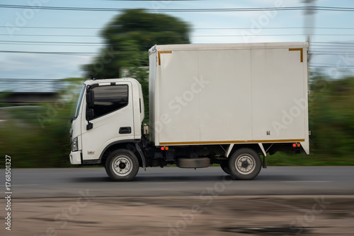 Side view of a small truck driving on a country road, truck running on the road, small truck on the road.