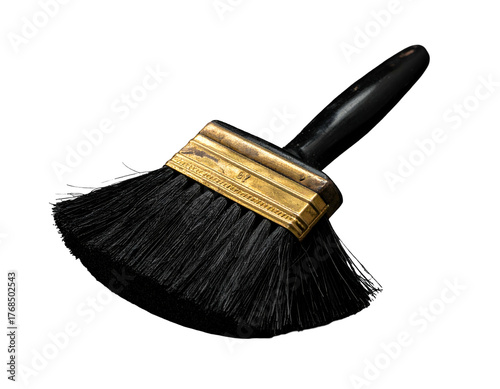 Black paint brush with a brass ferrule and black handle sits against a black background