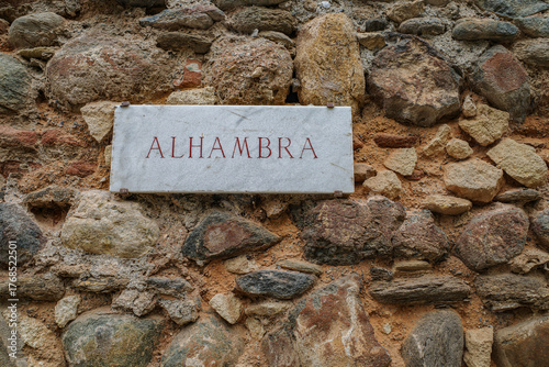 Granada, Spain - 21 Oct 2025: Sign for Alhambra at Gate of Justice on the ancient fortified wall of the hilltop fortress in Granada
