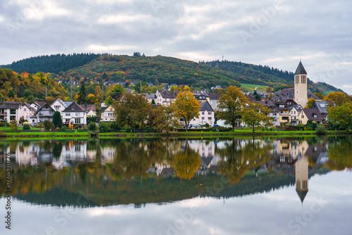 Bullay village at dawn with St. Mary's church reflected in Moselle river in Germany. Europe