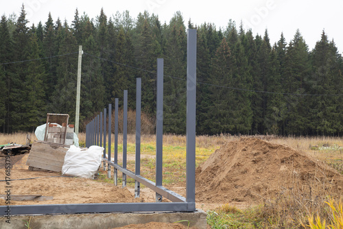 Installation of a fence around the house. Posts made of iron.