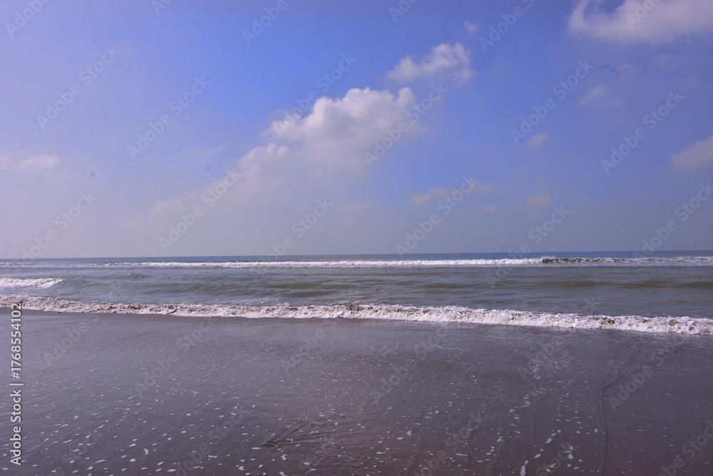Obraz premium The scenic view from Laboni Point, a popular tourist spot on Cox's Bazar beach. Calm waves of the Bay of Bengal meet the sand under a beautiful blue sky. A perfect Bangladesh travel image.