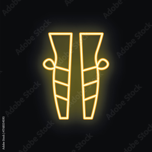 Neon sign of a pair of fashionable high heeled boots glowing yellow on black background
