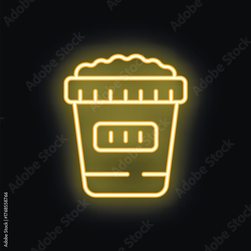 Yellow neon sign of popcorn bucket glowing on black wall