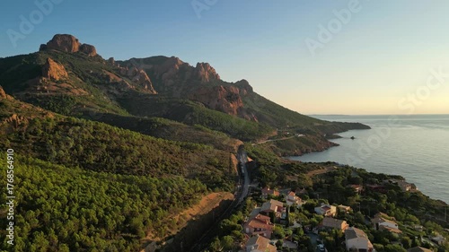 Aerial cinematic view of a train crossing the Antheor Viaduct in the Esterel Mountains near Saint Raphael, French Riviera, overlooking the Mediterranean Sea and luxury villas along the Cote dAzur at s