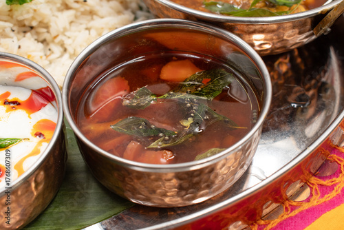Indian tomato rasam in traditional copper bowl