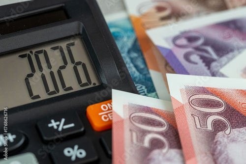 United Kingdom money. Finance 2026. Business and economic concept. Symbol of the British pound. The year 2026 displayed on a calculator. Financial background. Close up