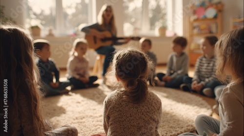 woman plays guitar for children in classroom