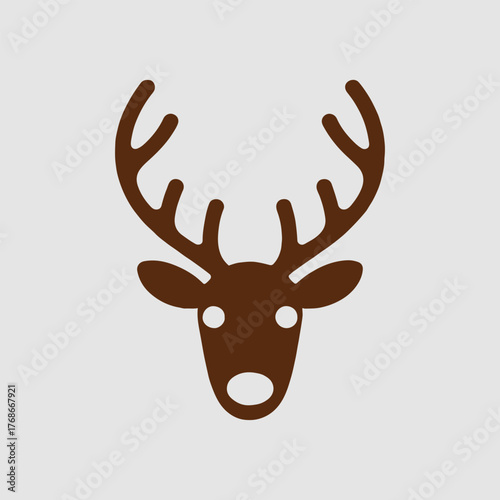 A brown deer head with large antlers and white eyes and nose on a light gray background surface area