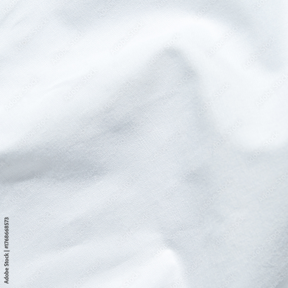 Obraz premium Close-up of white cotton fabric texture with soft folds and subtle shadows.