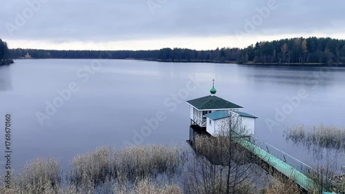 Tranquil Lake with Cozy Dock and Cabin Scene with an Orthodox cross on top