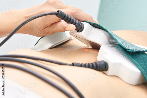 Close-up of female receiving non-invasive laser treatment for body contouring and fat reduction therapy.