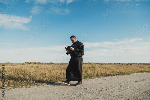 Fotografie Blue Sky Over The Priest Reading The Bible