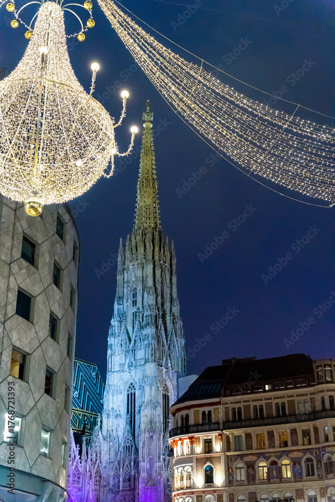 Fototapeta premium Gothic cathedral illuminated at night with Christmas street decorations in Vienna