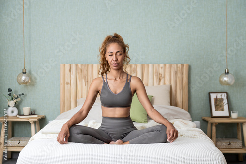 Morning mindfulness session of a woman sitting calmly in bed