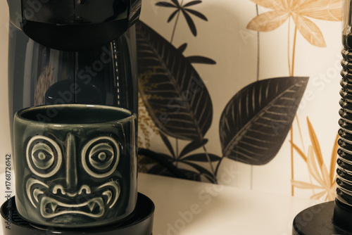 Demon-faced teacup in a coffee pot