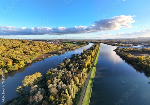 vue aérienne et panoramique de la Moselle entre Thionville et Metz, en fin de journée en automne. Ciel bleu mais nuageux, la partie de la rivière canalisée est sur la droite.