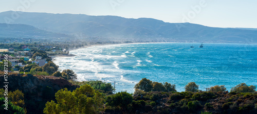 Scenic coastal view of Kissamos Bay with waves and distant boats in Crete