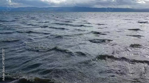 On the shore of the slightly stormy Lake Constance. The camera rises higher and higher from the water