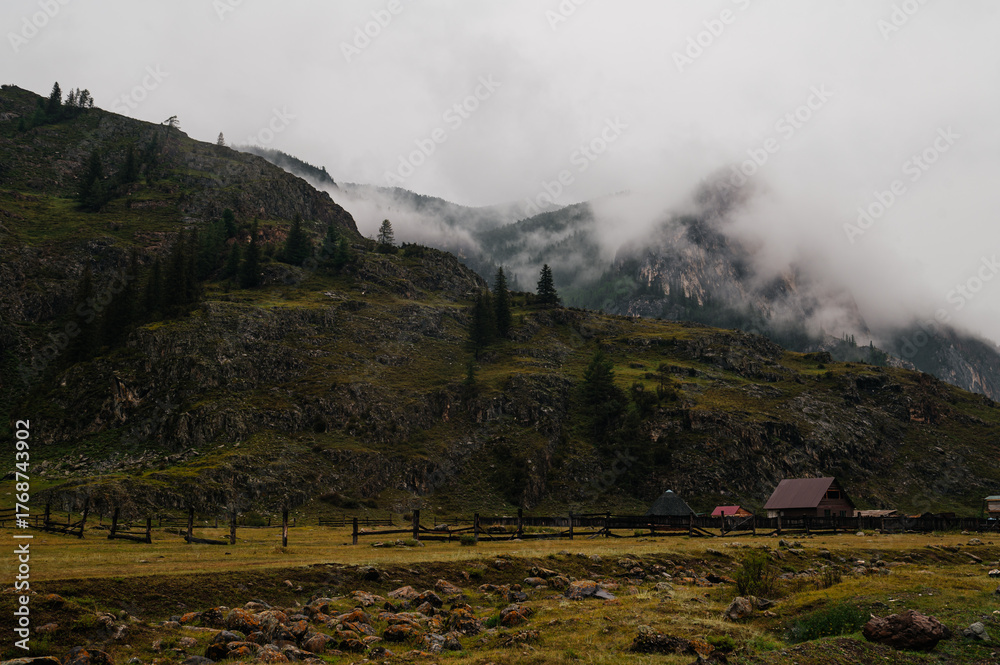 Fototapeta premium Mountains shrouded in fog and clouds in Altai, Russia
