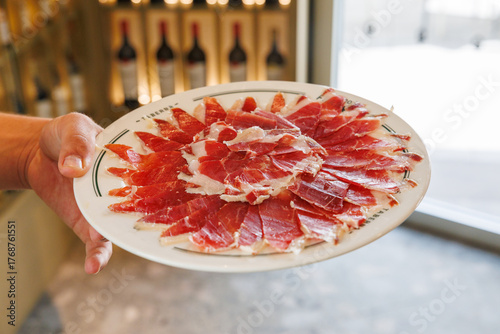Fotografia Serving traditional sliced spanish jamon serrano