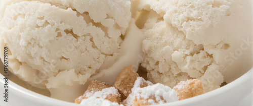 Creamy Vanilla Ice Cream with Powdered Sugar Pastry Pieces in White Bowl on Minimal Background