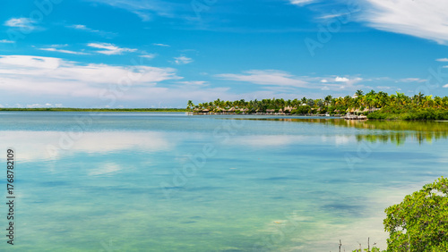 Fototapeta Naklejka Na Ścianę i Meble -  Serene seascape with palm-covered island and calm blue ocean