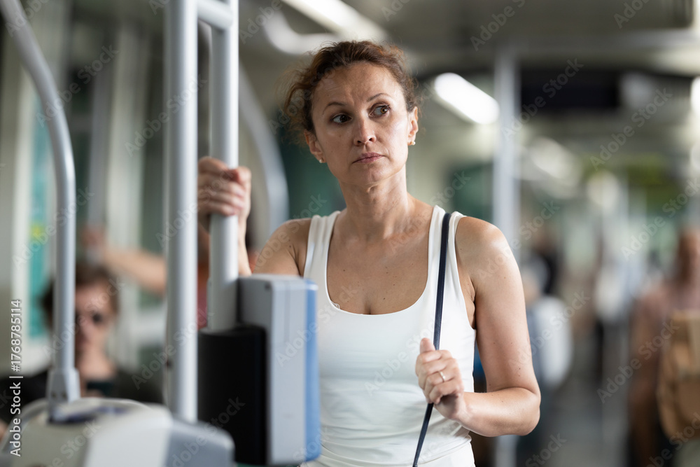 Obraz premium Adult woman riding standing in modern train carriage