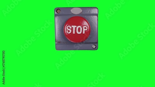hand pressing an industrial stop button green screen