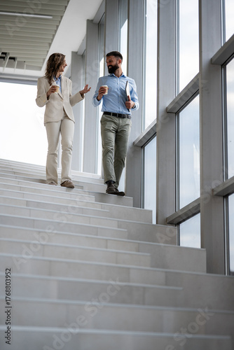 Obraz na płótnie Business colleagues walking down stairs, having conversation