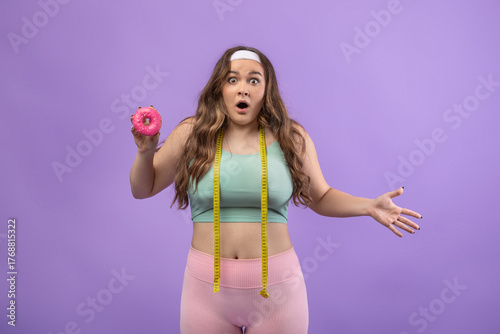 A shocked young european plus size lady in uniform stands against a purple background.