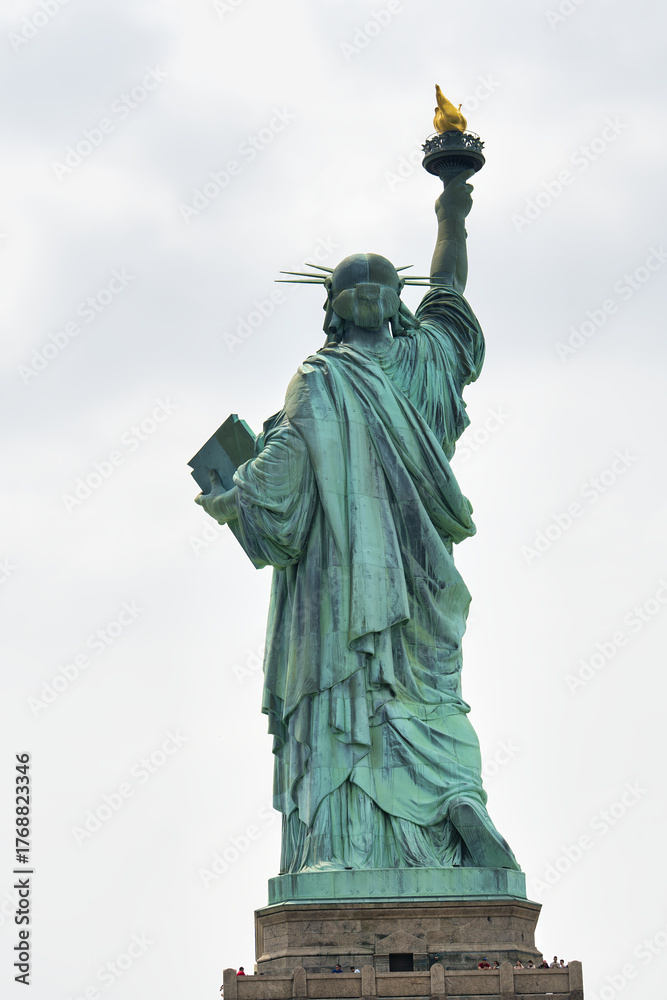 Obraz premium Perspective from behind Lady Liberty showing torch, crown, and New York Harbor
