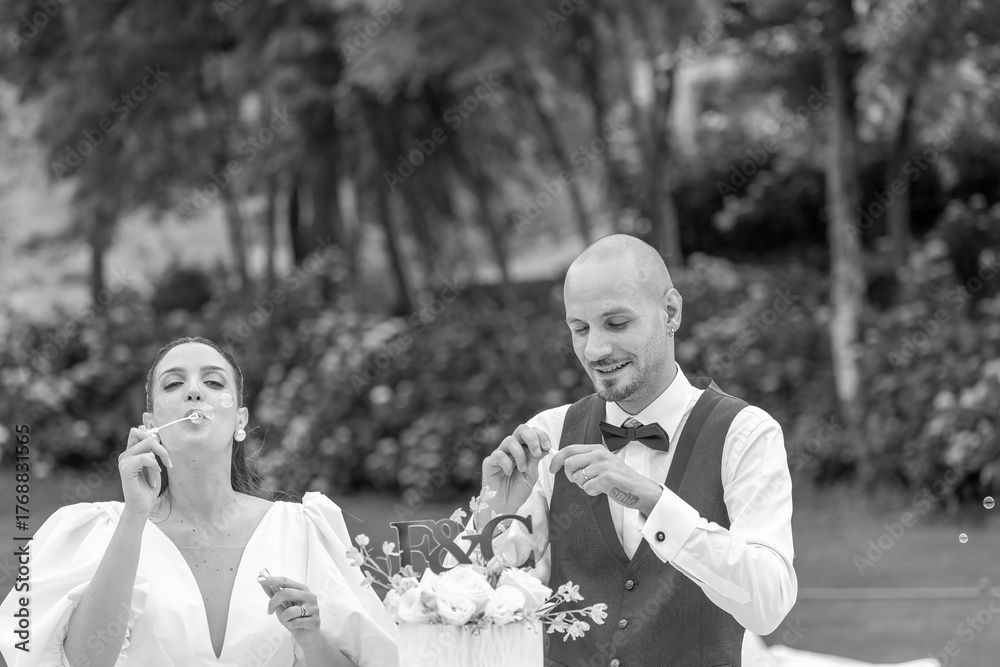 Fototapeta premium Bride and groom happily cutting their wedding cake together during the festive celebration