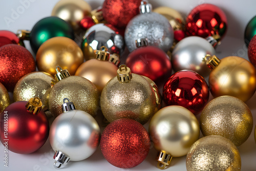 Collection of red gold and silver christmas ornaments scattered on white background