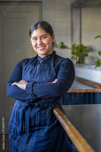 Smiling female chef standing confidently in kitchen