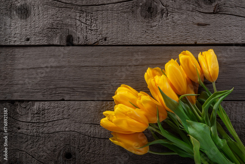 Yellow Tulips on Old Rustic Wooden Textured Surface.