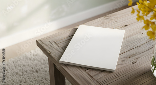 Contemporary home decor featuring a blank square booklet on a rustic wood table for product showcasing and advertising